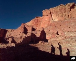 FILE - Tourists cast their shadows on the ancient Anasazi ruins of Chaco Canyon in New Mexico, Nov. 21, 1996.