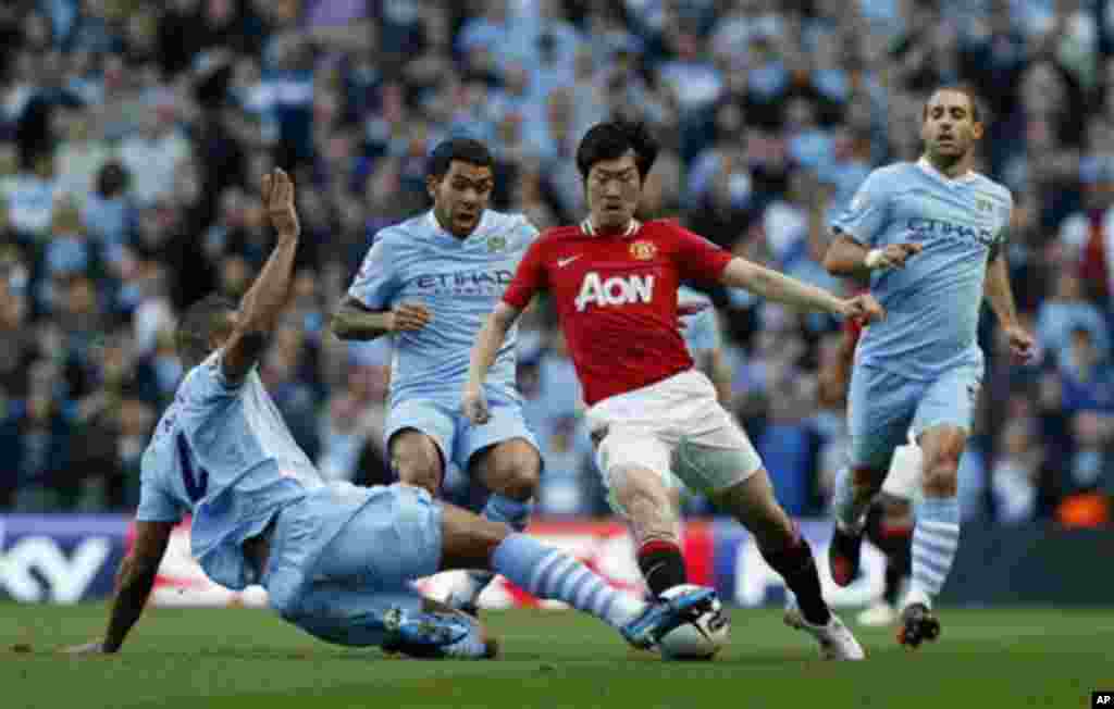 Manchester City's Vincent Kompany, left, competes for the ball with Manchester United's Park Ji-Sung, third left, watched by Carlos Tevez, second left, and Pablo Zabaleta, right, during the English Premier League soccer match between Manchester City and M