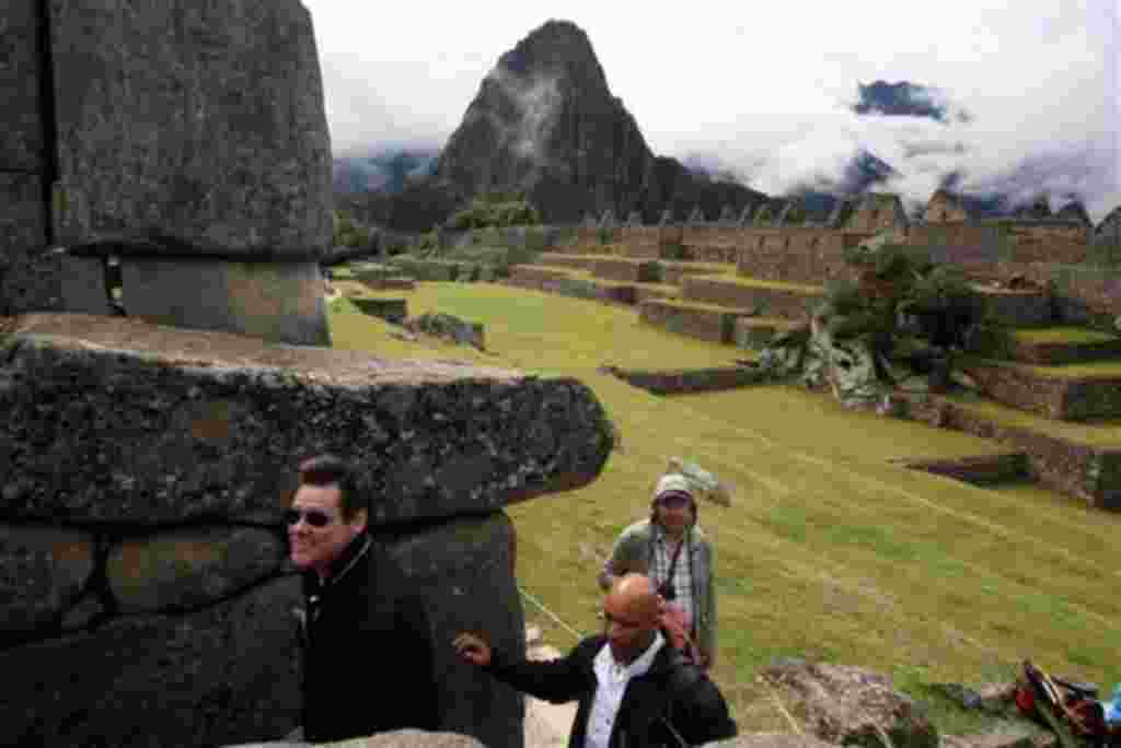 El actor canadiense Jim Carrey, a la izquierda, camina durante una visita a la ciudadela inca de Machu Picchu en Cuzco, Perú.