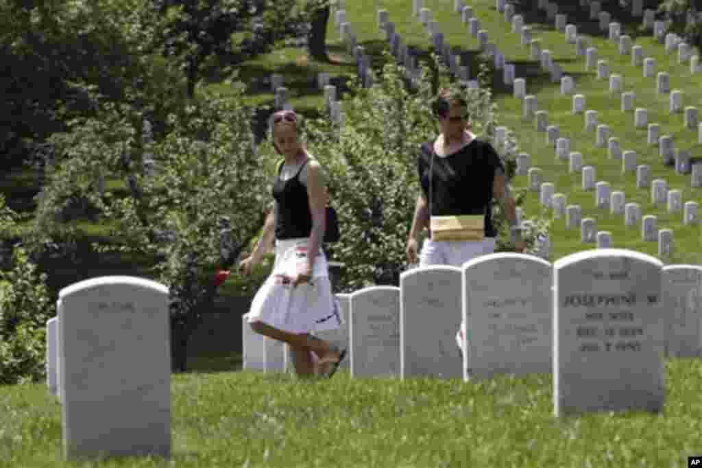 Visitors walk among the graves after attending a Memorial Day Observance at the Memorial Amphitheater at Arlington National Cemetery, Monday, May 28, 2012. (AP Photo/Charles Dharapak)