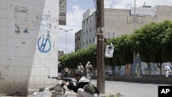 A tribesman aims his AK-47 while taking a position next to the house of Sheik Sadeq al-Ahmar, the head of the powerful Hashid tribe, during clashes with Yemeni security forces in Sana'a, Yemen, May 24, 2011.