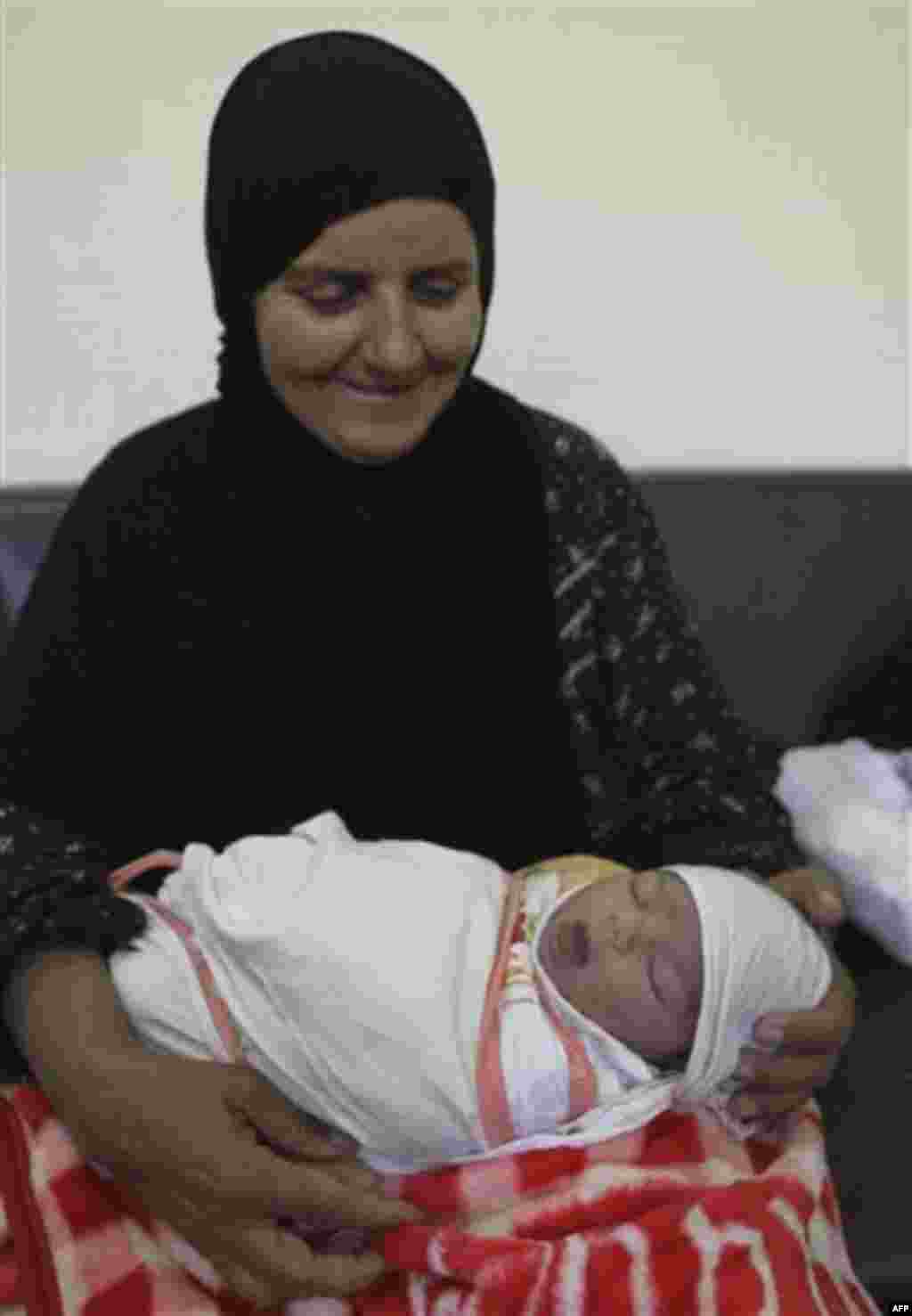 Umm Ahmed holds her granddaughter, Zahra Ahmer, born only an hour before, at a maternity hospital sponsored by the Iraqi Red Crescent Society in Baghdad, Iraq, Sunday, Oct. 30, 2011. According to Iraq's Health Ministry, Iraq witnesses the birth of more th