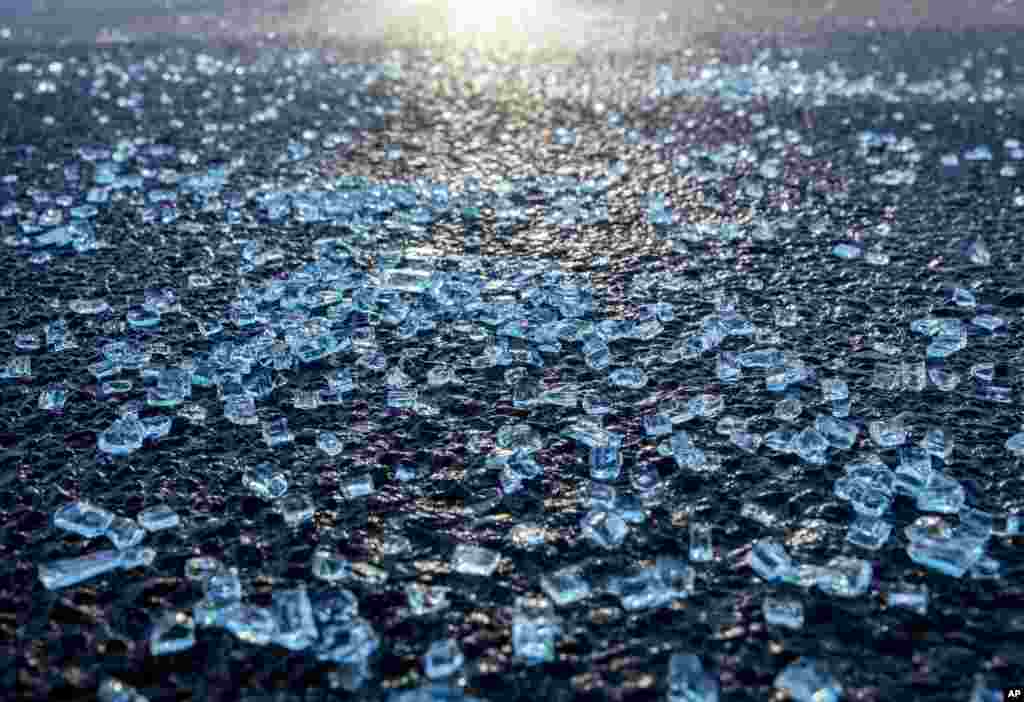 Broken glass from the window of a car in which a man was shot lies on the street in front of a kiosk in Hanau, Germany, two days after a 43-year-old German man shot and killed several people in a Frankfurt suburb on Feb. 19, 2020. 