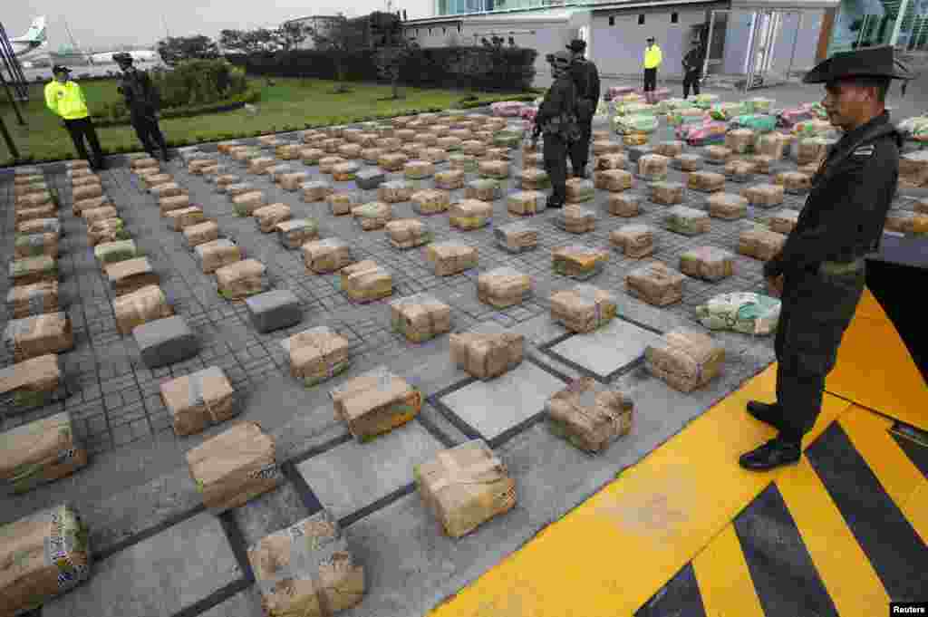 Anti-narcotics police officers stand guard near packages of marijuana at a police base in Bogota, Colombia. According to authorities, anti-narcotics police confiscated around 6 tons (5,879 kg) of marijuana during an operation named &quot;Republica III&quot; on Apr. 22, 2013.