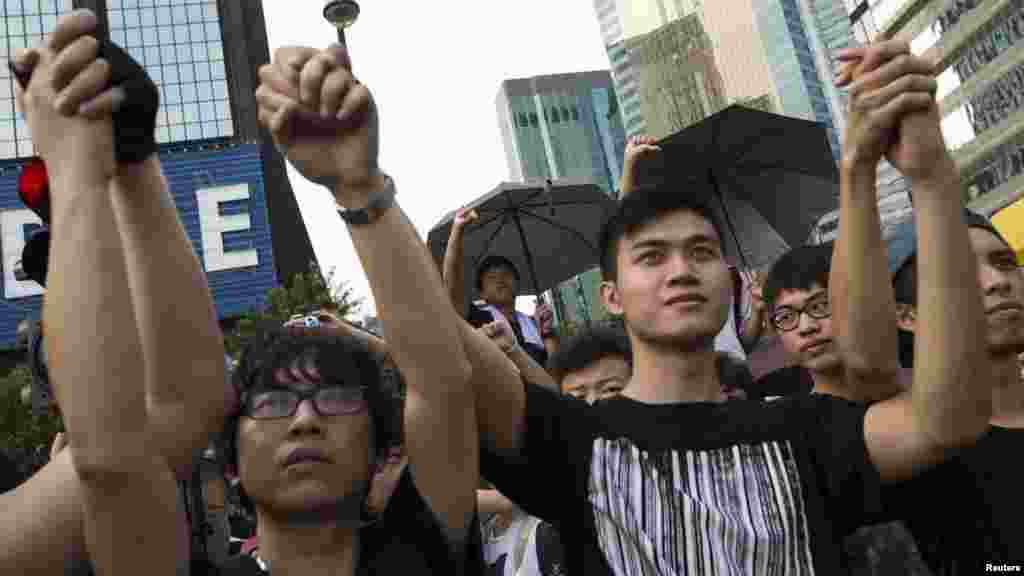 Student protesters gesture outside the Golden Bauhinia Square, venue of the official flag-raising ceremony for celebrations of China's National Day in Hong Kong, October 1, 2014.