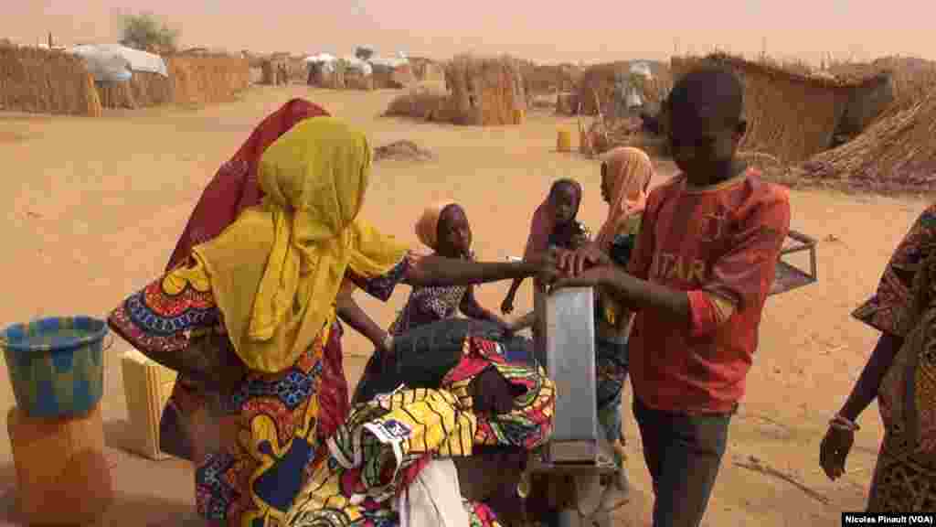 Des enfants autour de la pompe à eau dans le camp de réfugiés d'Assaga, Diffa, Niger, le 17 avril 2017 (VOA/Nicolas Pinault)