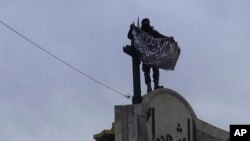 Gambar yang dipasang di akun Twitter Front al-Nusra menunjukkan seorang pejuang kelompok afiliasi al-Qaida itu mengibarkan bendera di provinsi Idlib (28/3).