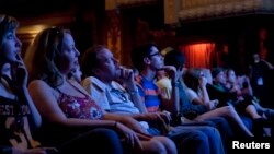 Audience members watch "Big Easy," a film at the Paramount Theater during the South by Southwest festival, Austin, Texas, March, 17, 2012.