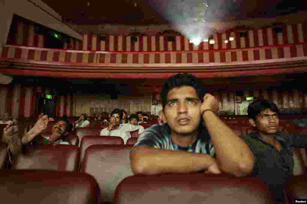Ram Pratap Verma, a 32-year-old aspiring Bollywood film actor, watches a film at a cinema in Mumbai, May 2, 2013.