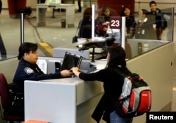 A foreign airline passenger is greeted by a Customs and Border Protection Officer at Hartsfield-Jackson International Airport in Atlanta, Georgia