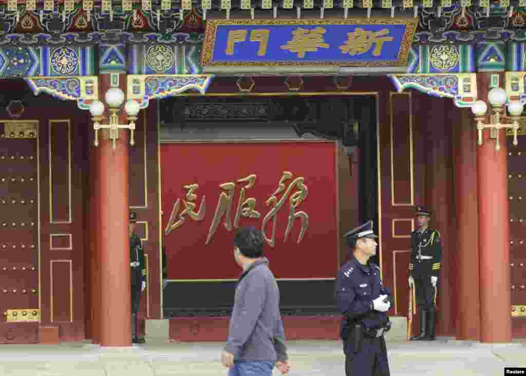 Soldiers and a policeman stand guard at Xinhuamen Gate, the main entrance of the Zhongnanhai leadership compound, the residence of Chinese President Xi Jinping, located in the center of Beijing, Oct. 31, 2013. 