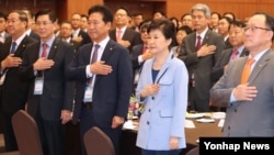 박근혜 한국 대통령이 13일 청와대에서 열린 민주평통 해외자문위원과의 통일대화에서 참석자들과 함께 국기에 대한 경례를 하고 있다.