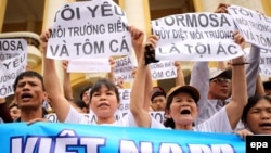 FILE - Vietnamese protesters hold banners reading "Formosa destroys the environment, which is a crime" and "I love the sea, shrimp and fish" during a rally denouncing recent mass fish deaths in Vietnam's central province, in Hanoi, Vietnam, May 1, 2016.