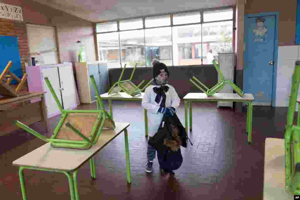 A student enters his public school classroom for the first time in three months since the lockdown to curb the spread of the new coronavirus pandemic in Montevideo, Uruguay.