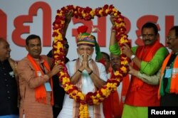 India's Prime Minister Narendra Modi is presented with a garland during an election campaign rally in Himmatnagar, Gujarat, April 17, 2019.