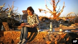 Chanell Gonzalez looks through her grandfather's yearbook which she found in his destroyed home in Joplin, Missouri, May 26, 2011