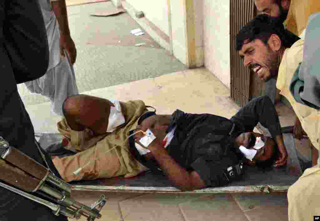 People carry a wounded police officer from the site of a bombing in Quetta, Pakistan, August 8, 2013.