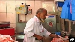 Butcher Haj Mohammed chops pieces of meat at his Halal butcher shop and wraps each carefully for his customers in in Paris's Muslim quarter