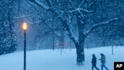 Warga berjalan melewati Taman Washington, Albany, New York yang dingin dan tertutup salju (2/1).