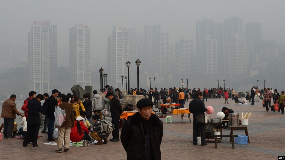 2013年2月，重庆居民在朝天门公园，背景是新建的社会保障房。薄熙来由于社会保障房等项目而在当地得人心，但也留下巨额债务