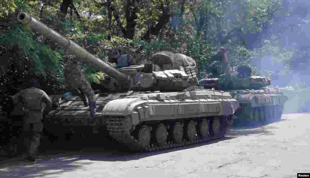 Pro-Russian troops prepare to travel in a tank on a road near the town of Yanakiyevo, Donetsk region, eastern Ukraine, June 20, 2014.