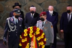 Presiden Jerman Frank-Walter Steinmeier (tengah), meletakkan karangan bunga saat berkunjung ke Hall of Remembrance di Yad Vashem Holocaust memorial di Yerusalem, Kamis, 1 Juli 2021. (AP Photo/Ariel Schalit)