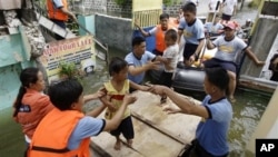 Rescuers move children to an evacuation center at Malabon city, north of Manila, Philippines, Aug. 1, 2012.