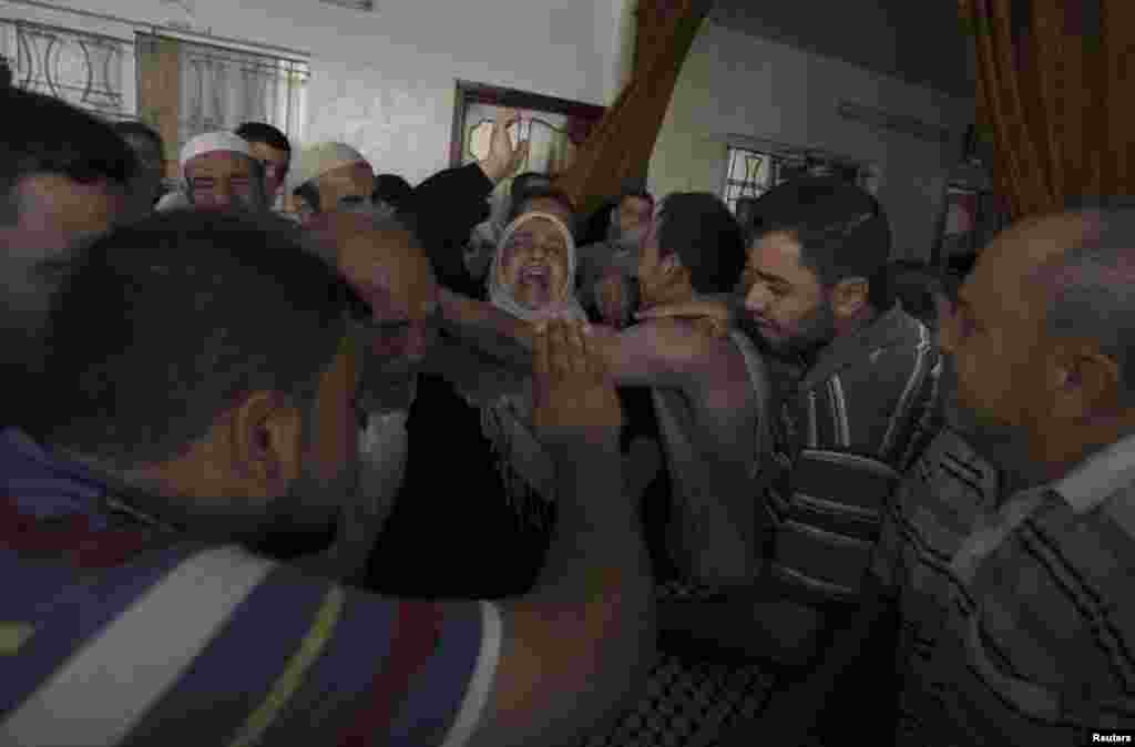 Ibu dari warga Palestina Hamed Shehab, yang menurut petugas medis tewas dalam serangan udara Israel yang menimba mobil warga sipil, berduka dalam upacara pemakaman putranya di Gaza City (10/7). (Reuters/Ashraf Amrah)