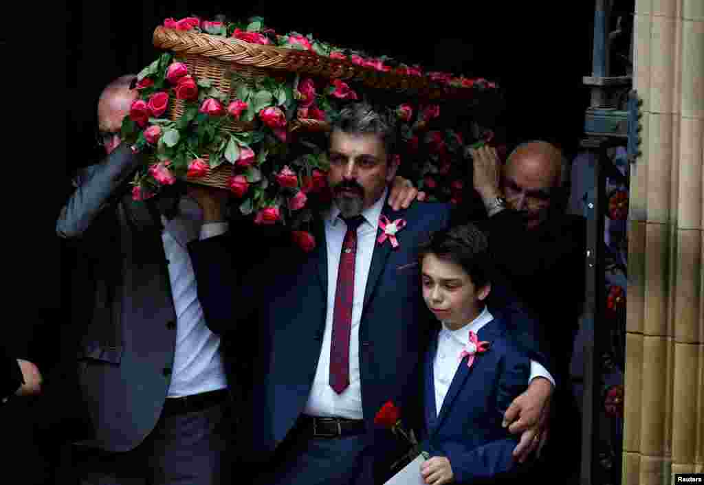 Andrew Roussos puts a hand around his son Xander as he carries his daughter Saffie Rose Roussos&#39; coffin, the youngest victim of the bombing of the Manchester Arena, at her funeral at Manchester Cathedral, Britain.