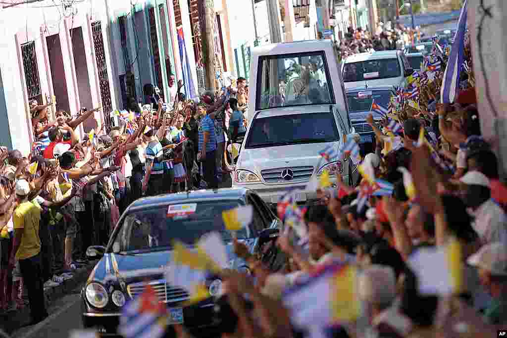 Pope Benedict rides in the popemobile as people gather along the roadside to greet him upon his arrival to Santiago de Cuba, March 26, 2012. (AP/Osservatore Romano)