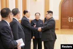 North Korean leader Kim Jong Un, right, meets members of the high-level delegation of the Democratic People's Republic of Korea, which visited South Korea to attend the opening ceremony of the 23rd Winter Olympics.