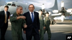 Australian Prime Minister Tony Abbott is guided around a Royal Australian Air Force P-3C Orion aircraft by Australian Air Force Group Commander Craig Heap, second from left, in Bullsbrook, near Perth, Australia, March 31, 2014.