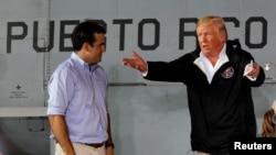 FILE - U.S. President Donald Trump talks with Puerto Rico Governor Ricardo Rossello (L) as they take their seats for a briefing on hurricane relief efforts in a hangar at Muniz Air National Guard Base in Carolina, Puerto Rico, Oct. 3, 2017.