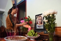 Thân nhân thắp nhang trên bàn thờ cô Bùi Thị Nhung, một trong 39 nạn nhân, 26 tháng 10, 2019.