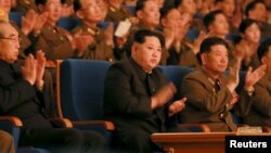 ຜູ້ນຳ ເກົາຫຼີເໜືອ ທ່ານ Kim Jong Un, ກາງ, ຕົບມືໃນ ລະຫວ່າງການສະແດງຄອນເສີດ ໃນຮູບພາບທີ່ບໍ່ລະບຸວັນທີ ເປີດເຜີຍໂດຍອົງການສູນກາງຂ່າວ ເກົາຫຼີ ຂອງ ເກົາຫຼີເໜືອ ໃນນະຄອນຫຼວງ ພຽງຢາງ, 23 ກຸມພາ, 2016.