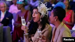 Pinky Ghelani and Suzzy Wokabi watch a TV broadcast of Britain's Prince Harry and Meghan Markle's royal wedding at the Windsor golf and country club in Nairobi, Kenya, May 19, 2018.