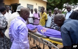 Relatives and onlookers watch as the body of South Sudanese journalist Peter Moi is taken into a mortuary in Juba, South Sudan, Aug. 20, 2015.