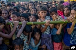 FILE - Rohingya Muslim children, who crossed over from Myanmar into Bangladesh, wait to receive aid during a distribution near Balukhali refugee camp, Bangladesh, Sept. 25, 2017.