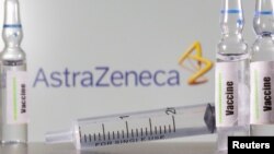 FILE PHOTO: A test tube labelled with the word Vaccine is seen in front of AstraZeneca logo in this illustration taken, September 9, 2020.