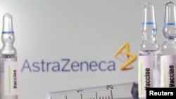 FILE PHOTO: A test tube labelled with the word Vaccine is seen in front of AstraZeneca logo in this illustration taken, September 9, 2020.