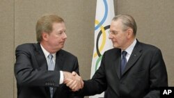 United States Olympic Committee chairman Larry Probst, left, and Olympic Committee President Jacques Rogge shake hands after signing an agreement between the IOC and the USOC at the SportAccord conference in Quebec City, May 24, 2012 (AP).