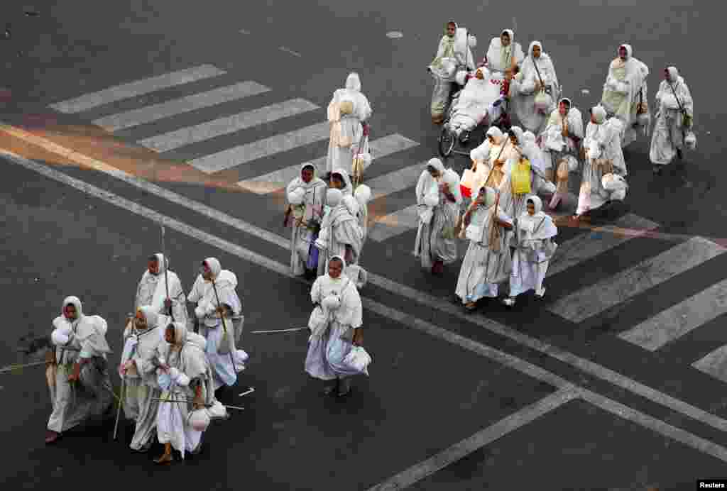 Para biarawati komunitas Jain yang mengikuti agama yang didirikan oleh Mahavir, menyeberang jalan di Ahmedabad, India.
