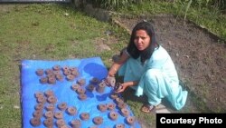 A briquette producer trained by Legacy Foundation instructors displays her wares (Photo: Legacy Foundation)