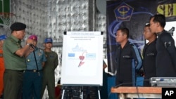 Indonesian military chief Gen. Moeldoko, left, briefs navy divers onboard the navy vessel KRI Banda Aceh in an area where they found the tail of AirAsia Flight 8501 on the Java Sea, Indonesia, Jan. 8, 2015. 
