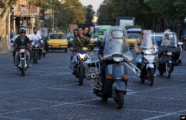 People ride motorcycles in downtown Tehran, Iran, Oct. 8, 2017.