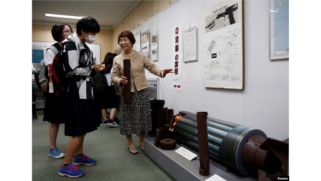 FILE - Haruyo Nihei explains to school girls visiting a museum about the March 10, 1945, U.S. firebombing in Tokyo, Japan, April 19, 2019.