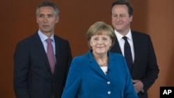 German Chancellor Angela Merkel, center, British PM David Cameron, right, and Norway's PM Jens Stoltenberg, left, arrive for a panel discussion in Berlin, Germany, June 7, 2012.