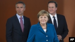 German Chancellor Angela Merkel, center, British PM David Cameron, right, and Norway's PM Jens Stoltenberg, left, arrive for a panel discussion in Berlin, Germany, June 7, 2012.