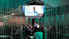 People follow a debate on the opening day of a three-day Youth for Climate summit in Milan, Italy, Tuesday, Sept. 28, 2021. (AP Photo/Luca Bruno)