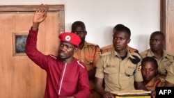 Opposition figurehead Robert Kyagulanyi, aka Bobi Wine, lifts his hand in the dock in the court room in Kampala, April 29, 2019. 